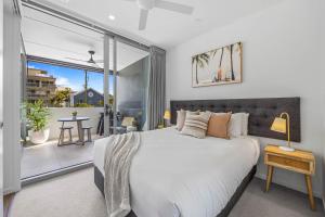 a bedroom with a large bed and a balcony at Executive Beachside Getaways in Maroochydore