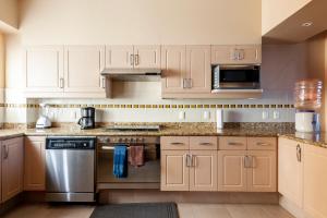 una cucina con armadietti bianchi ed elettrodomestici in acciaio inossidabile di Luxury Condo Steps Away from Downtown San Miguel a San Miguel de Allende