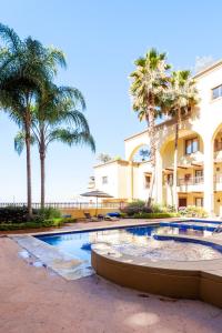 una piscina di fronte a un edificio con palme di Luxury Condo Steps Away from Downtown San Miguel a San Miguel de Allende