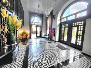 a lobby with a black and white tiled floor and windows at YO Hotel in Hải Dương