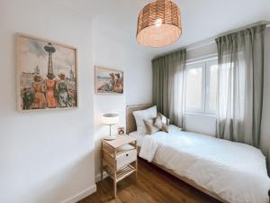 a bedroom with a white bed and a window at BetterBeds Berlin in Berlin