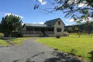 une grande maison blanche avec une allée dans l'établissement Shinglers Cottage, à Mayers Flat