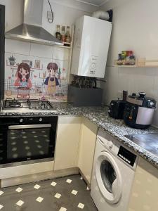 una cocina con estufa y lavadora en Cosy Room4 in London Kings Cross, en Londres