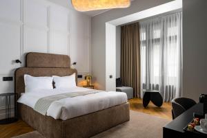 a bedroom with a large bed and a living room at Ecletico Villa in Bucharest