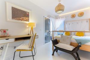 a bedroom with a bed and a desk and chairs at Mouna's House in Tabaiba