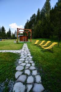 a stone path with two benches and a playground at Casuta Armonia in Moisei +17 photos