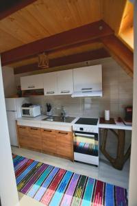 a kitchen with white cabinets and a sink and a stove at Casuta Armonia in Moisei +11 photos