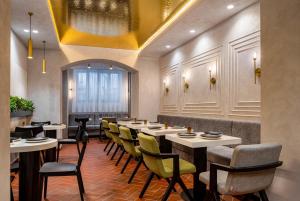 a restaurant with tables and chairs and a yellow ceiling at Ecletico Villa in Bucharest
