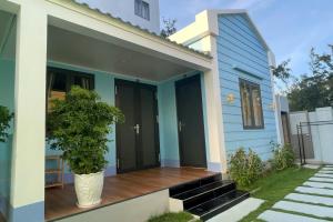 ein blaues Haus mit einer Pflanze auf der Veranda in der Unterkunft An Phú Villa in Cu Lao Thu