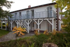 een wit huis met een balkon erbovenop bij Fewo Rosenhof TW 112 in Kühlungsborn