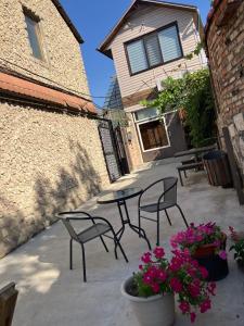 a patio with two chairs and a table and flowers at NewHome in Chişinău