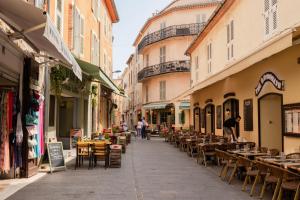 an empty street with tables and chairs and buildings at Studio design - Coup de coeur in Antibes