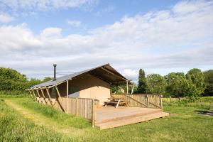 a large building with a deck in a field at Seven Hills Hideaway - Three Bedroom in Llanvetherine