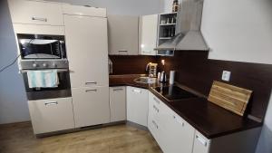 a kitchen with white cabinets and a black counter top at Liptovská Panoráma in Liptovský Mikuláš