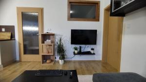 a living room with a television on a wall at Liptovská Panoráma in Liptovský Mikuláš