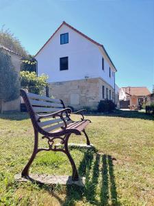 eine Parkbank im Gras vor einem Haus in der Unterkunft Casa Loural in Redondela
