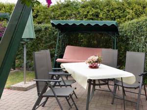 a patio with a table and chairs under a umbrella at Ferienbungalow Thesenvitz in Thesenvitz