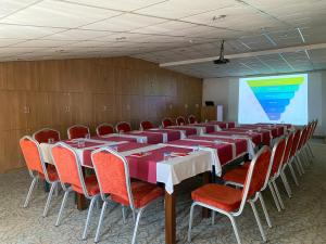 a conference room with tables and chairs and a screen at Ali Bilir Otel in Beysehir