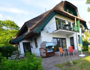 a house with a thatched roof and a patio at Reethäuser 17 Fam Kröning in Groß Zicker