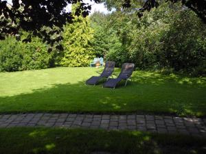 two chairs sitting in the grass in a yard at "Ferien vom Ich" - Fam Roman Kurth in Güstelitz