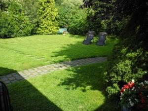 two chairs sitting in a grassy yard with trees at "Ferien vom Ich" - Fam Roman Kurth in Güstelitz