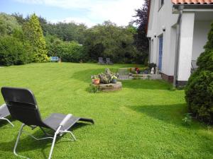 a chair sitting on the grass in a yard at "Ferien vom Ich" - Fam Roman Kurth in Güstelitz