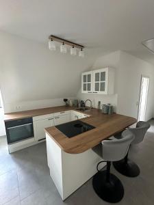 a kitchen with a wooden counter top and white cabinets at Ferienwohnung Altstadtblick in Wolframs-Eschenbach