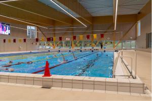 a large swimming pool with many people in it at la maison de westende in Middelkerke