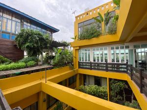 un edificio amarillo con plantas a su lado en Sourire at Rattanakosin Island Hotel, en Bangkok