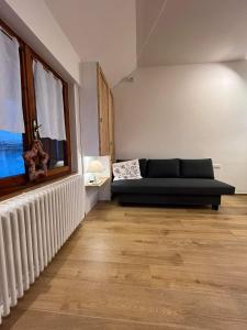 ein Wohnzimmer mit einer Couch und einem Fenster in der Unterkunft Casa vacanza La Genziana in Roccaraso