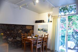 a dining room with a wooden table and a stone wall at Casa Tijoco in Adeje