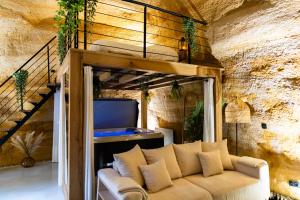 A television and/or entertainment centre at Le temps suspendu, Nuit sous la roche & jacuzzi