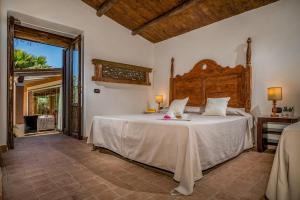 a bedroom with a large bed with a wooden headboard at VILLA ANTURA 4, Emma Villas in Castelvetrano Selinunte +24 photos