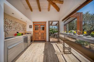 カステルヴェトラーノにあるVILLA PINETA 6, Emma Villasの長いカウンターと木製のドアのあるキッチン
