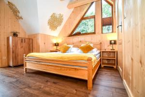a bedroom with a bed with two night stands and two windows at Domek Jatka No 1 in Zakopane