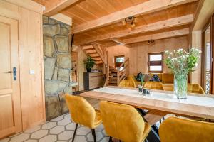 a dining room with a large wooden table and yellow chairs at Domek Jatka No 1 in Zakopane