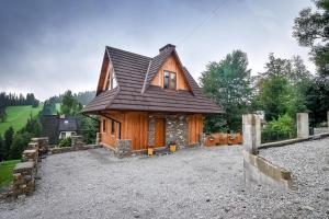 a house with a gambrel roof on a gravel yard at Domek Jatka No 1 in Zakopane