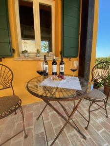 a table with two bottles and two glasses of wine at Country House Il Sassòne in Camerano