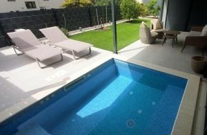 トロギールにあるUNIQUE Trogir - garden with PRIVATE heated massage POOL ONLY FOR YOUのスイミングプール(椅子2脚、テーブル付)