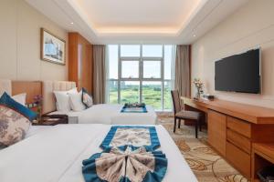 Voodi või voodid majutusasutuse Metropolo Jinjiang Yongqing Daxing International Airport Hotel toas