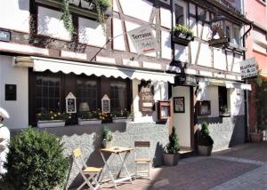 a building with chairs and a table in front of it at Muemling Apartments in Erbach