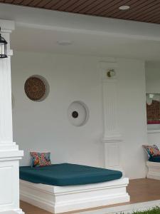 Una habitación blanca con un banco con un cojín azul. en Carmel Retreat, en San Pablo