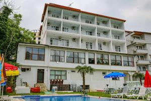 埃利特温泉Green Moringa Termal Hotel的一座白色的大楼，前面有一个游泳池