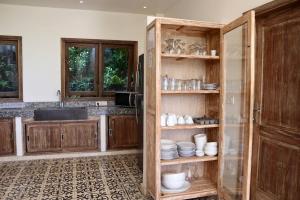 a kitchen with wooden cabinets and plates on shelves at Villa Masna Spacious 4 bdr in Canggu in Denpasar