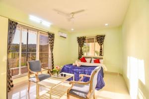 ein Schlafzimmer mit einem Bett, einem Tisch und Stühlen in der Unterkunft 4BHK VERONICA VILLA by Welcome Stays in Lonavla