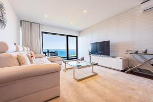 un salon avec un canapé et une télévision à écran plat dans l'établissement Serenity by the Sea, à Funchal
