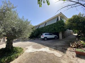 una macchina bianca parcheggiata di fronte a una casa di Tomi & Fonti a Guadamur