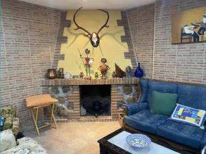 un soggiorno con un divano blu e un camino di Tomi & Fonti a Guadamur