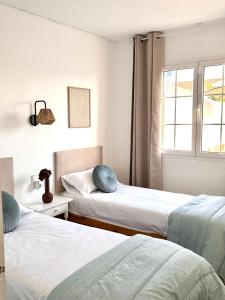 a bedroom with two beds and a window at Chalets con piscinas privadas junto al mar in Cala'n Bosch