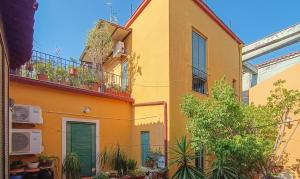 un edificio amarillo con plantas en un balcón en Casa Rossi, en Acireale